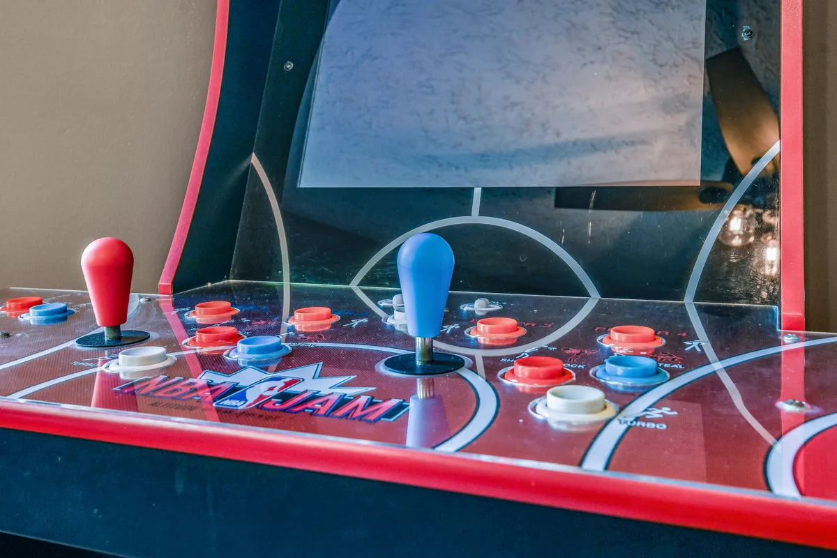 A close-up of an arcade machine with colorful buttons and joysticks, ready for hours of nostalgic gameplay. The mood is playful, capturing the essence of classic arcade competition and shared fun.
